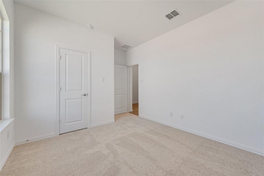 Unfurnished bedroom with light colored carpet