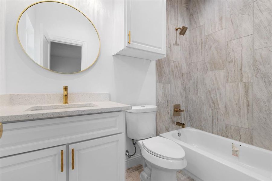 Full bathroom featuring tiled shower / bath, vanity, and toilet