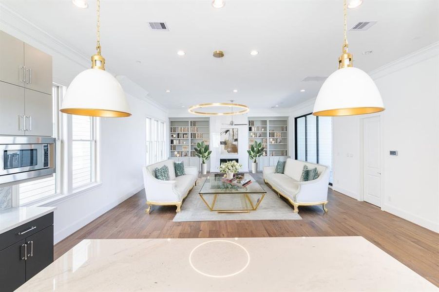 Living area with a floor-to-ceiling marble fireplace and built-in shelving/cabinets with 10' tall glass sliding doors leading to a huge balcony.