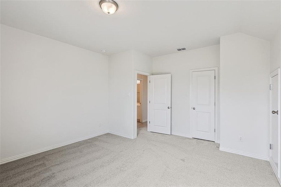 Unfurnished bedroom with light carpet