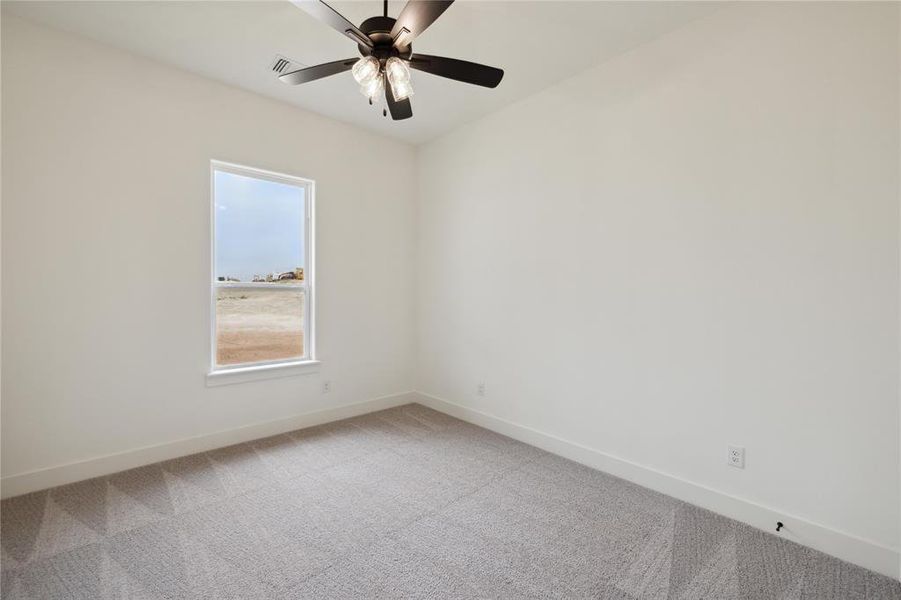 Spare room featuring ceiling fan and carpet floors