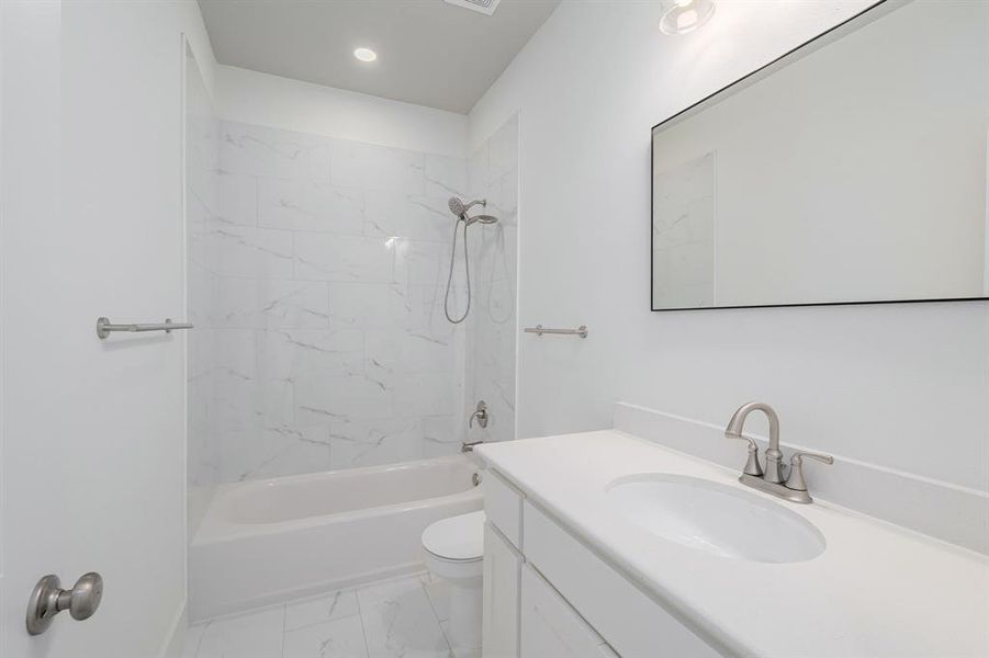 Full bathroom with vanity, toilet, and tiled shower / bath