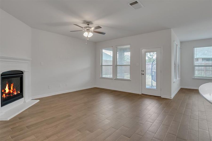 Unfurnished living room with ceiling fan and light hardwood / wood-style floors