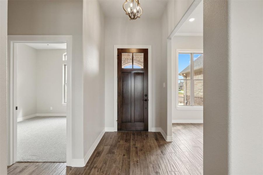 Foyer entrance with a chandelier and hardwood / wood-style flooring