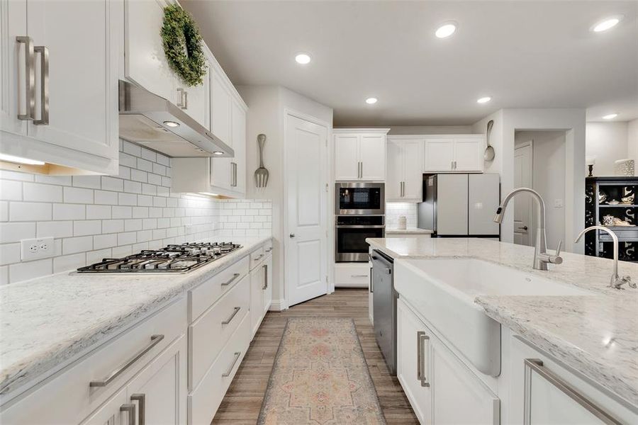 Beautiful kitchen with white cabinets, subway tile backsplash & farmhouse sink