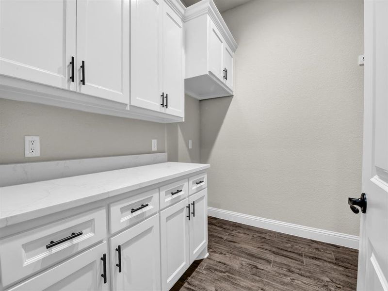 Clothes washing area with dark wood-type flooring