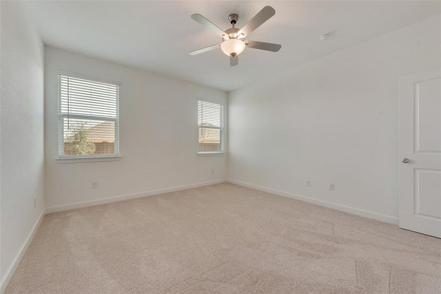 Carpeted empty room featuring ceiling fan