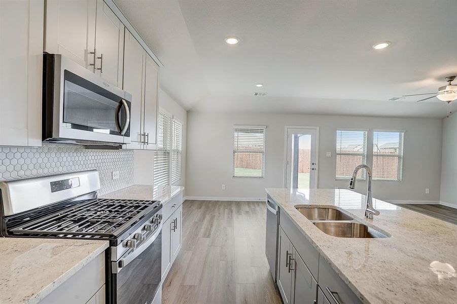 Kitchen featuring light stone countertops, appliances with stainless steel finishes, plenty of natural light