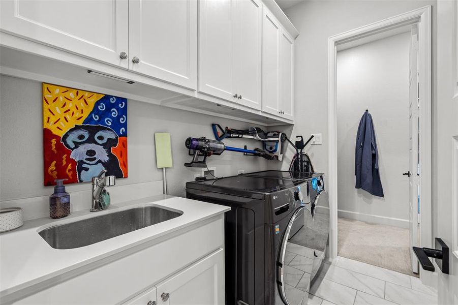 Laundry room featuring light carpet, washer hookup, sink, separate washer and dryer, and cabinets