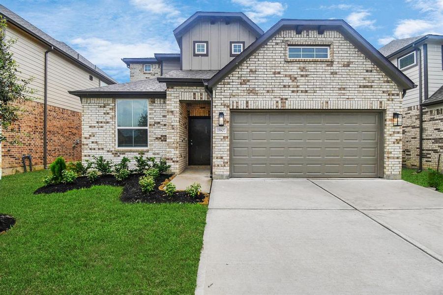 Meticulously maintained yard and lush landscape, paired with a premium elevation featuring captivating brick accents. Modern coach lights add a touch of contemporary elegance to the exterior.