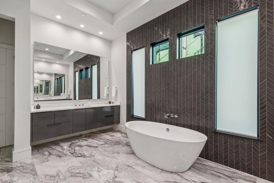 Bathroom featuring tile patterned flooring, vanity, a tray ceiling, and independent shower and bath