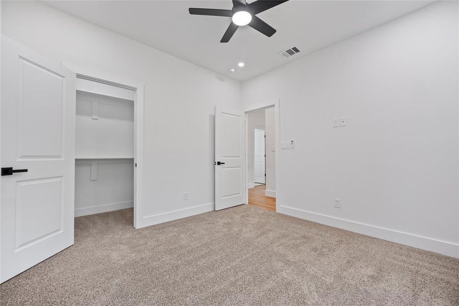 Unfurnished bedroom with ceiling fan, a closet, and carpet flooring