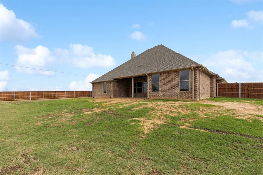 Rear view of property with a yard