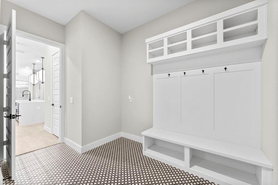 Spacious utility room featuring drop zone cubbies and additional space for an extra refrigerator.