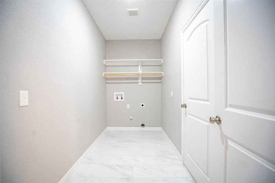 Laundry room featuring light tile patterned floors, hookup for a washing machine, and electric dryer hookup