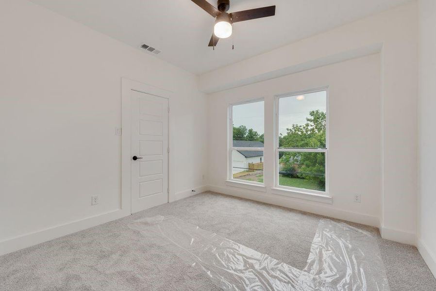 Spare room featuring light colored carpet and ceiling fan