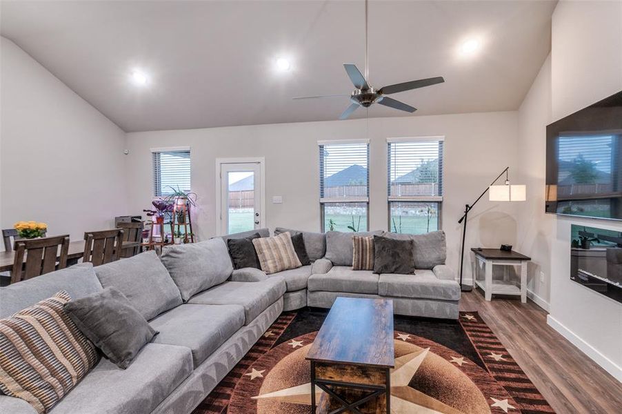 Living room featuring lofted ceiling, ceiling fan, and dark hardwood / wood-style floors