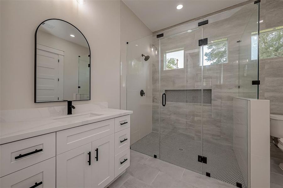 You have a custom glass door in your primary bathroom, elevating this entire space.