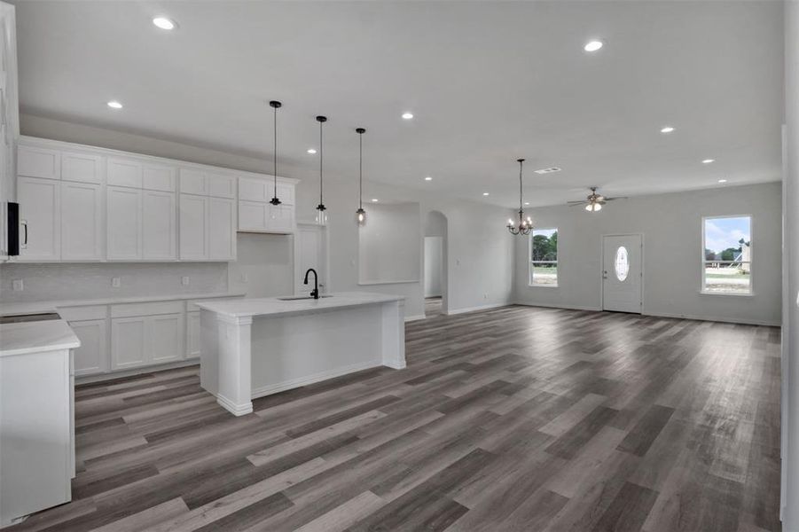 Kitchen featuring a kitchen island with sink, white cabinets, hardwood / wood-style flooring, and sink