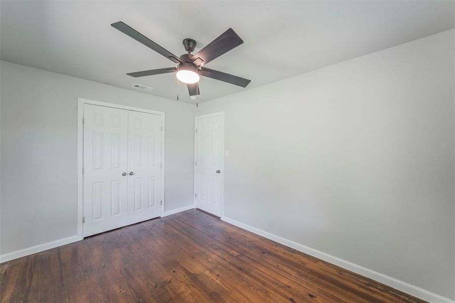 Bedroom with wood-type flooring, a closet, and ceiling fan