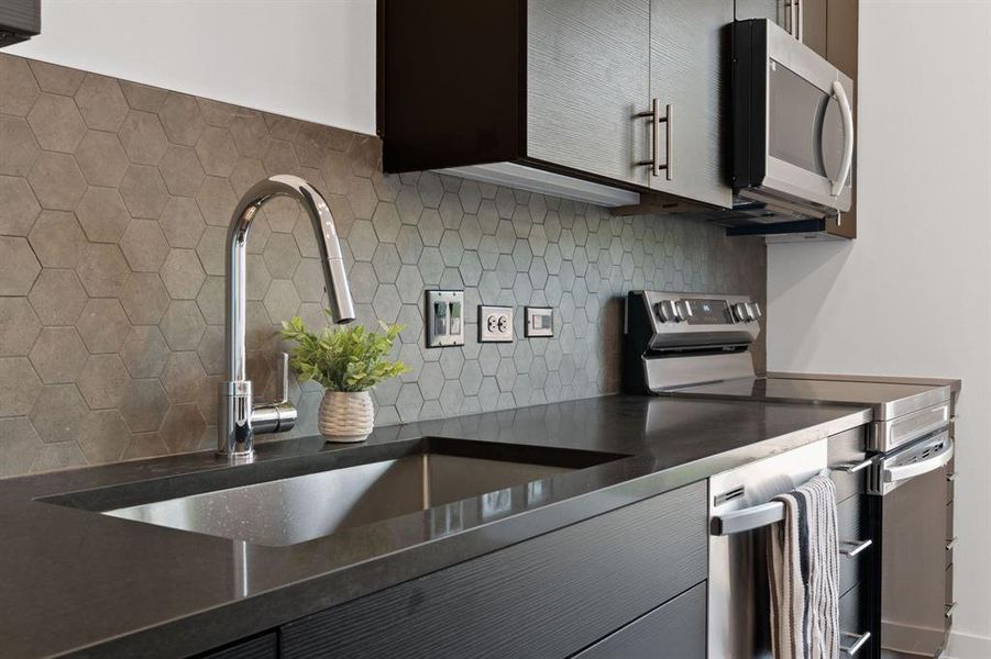 Sleek quartz counters with stainless undermount sink.