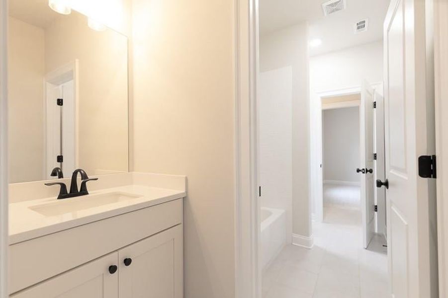 Bathroom with vanity, shower / tub combination, and tile flooring. Photo not actual home, but previously built Mansfield plan.