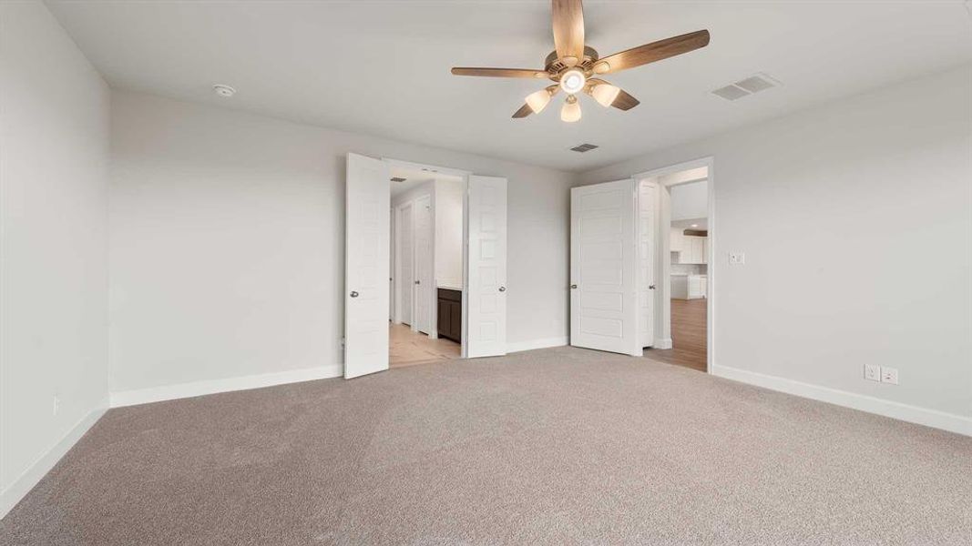 Unfurnished bedroom featuring ceiling fan and light colored carpet