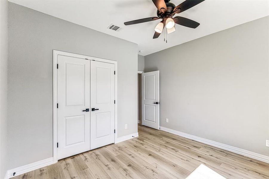 Unfurnished bedroom featuring light hardwood / wood-style flooring, ceiling fan, and a closet