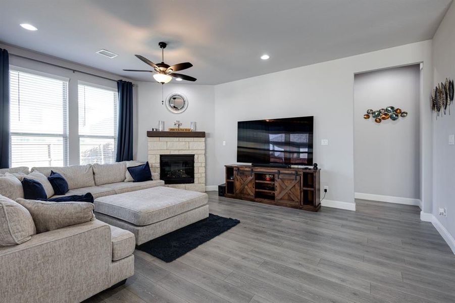 Living room featuring ceiling fan, hardwood / wood-style flooring, and a fireplace