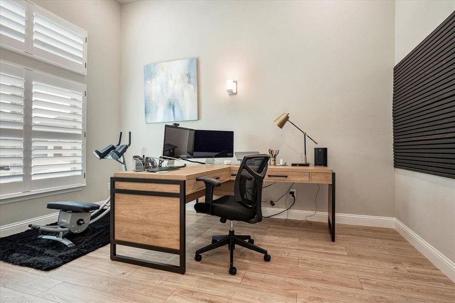 Office featuring a high ceiling and light hardwood / wood-style flooring