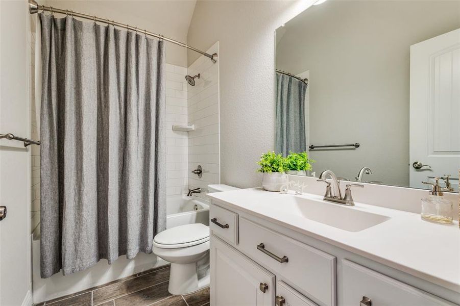 Full bathroom with vanity, toilet, and shower / bath combination with curtain