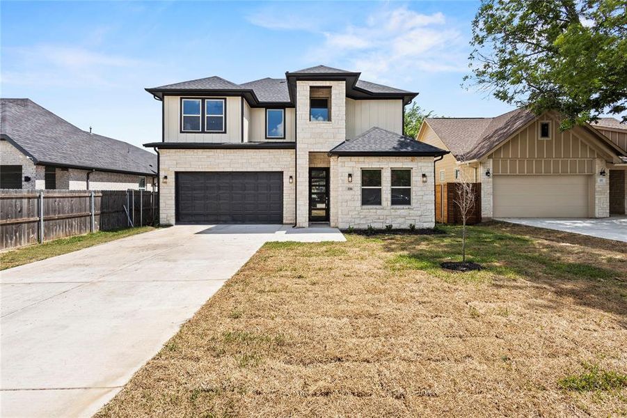 View of front of house with a front lawn and a garage