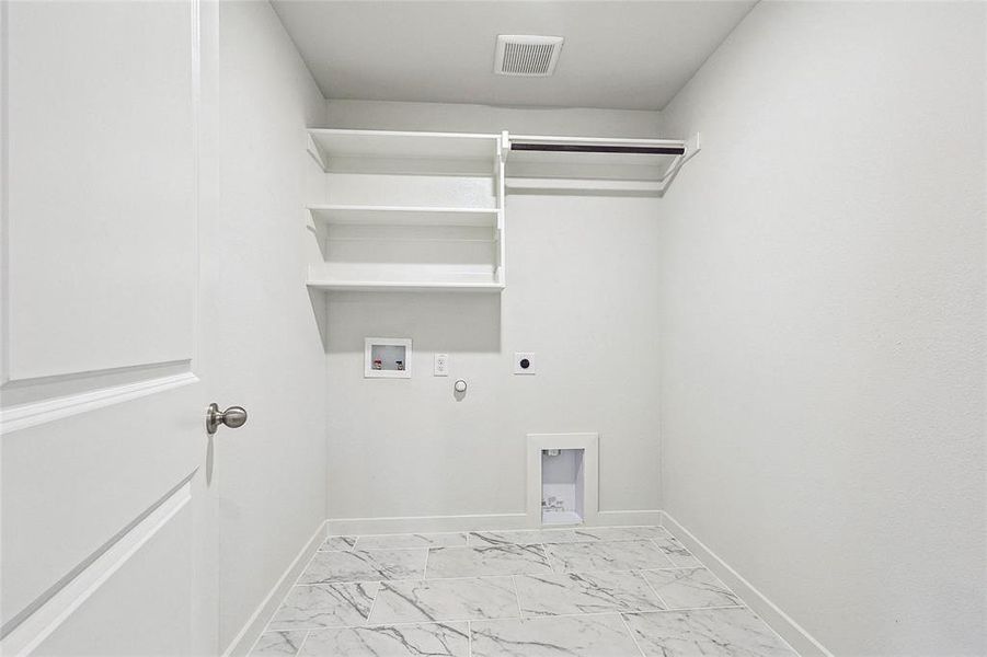 Clothes washing area featuring hookup for a washing machine, hookup for an electric dryer, light tile patterned floors, and hookup for a gas dryer