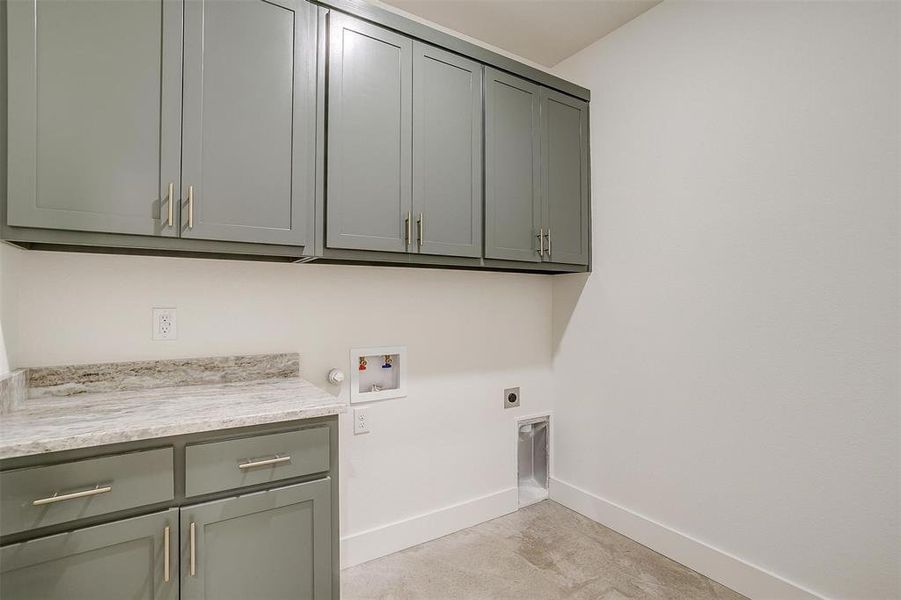 Washroom featuring hookup for an electric dryer, washer hookup, and cabinets