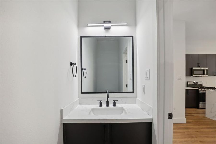 First floor half bath with quartz countertops and upgraded fixtures