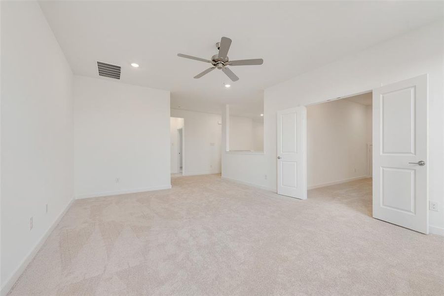 Unfurnished bedroom featuring ceiling fan and light colored carpet