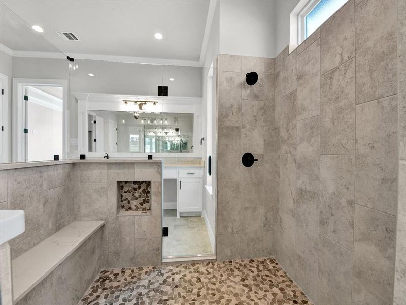 Bathroom with a tile shower, crown molding, tile patterned flooring, and vanity