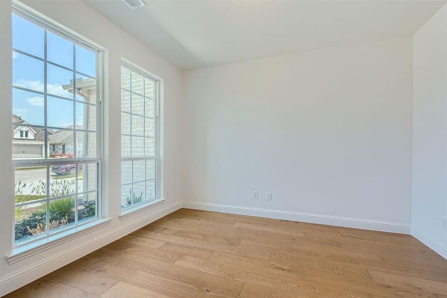 Empty room with light hardwood / wood-style floors