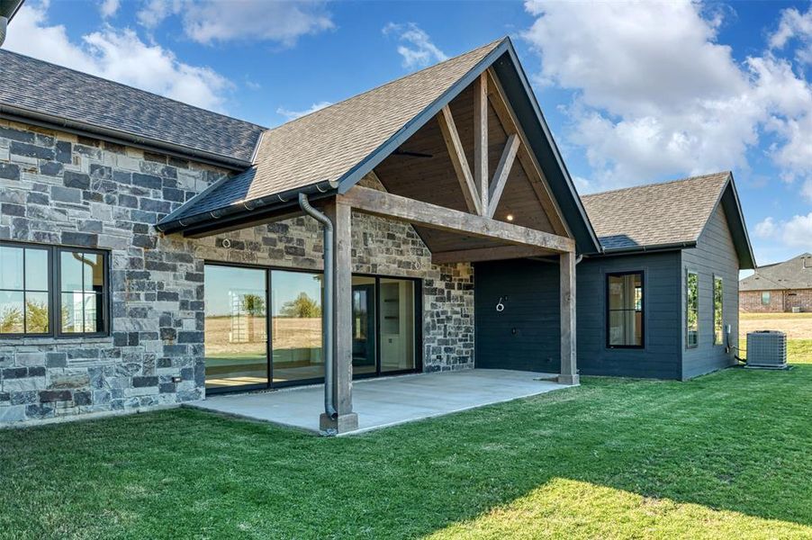 Back of property featuring a patio, central air condition unit, and a lawn