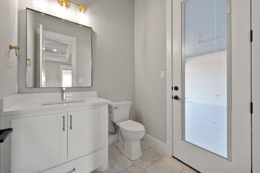 Bathroom with vanity, toilet, and a wealth of natural light