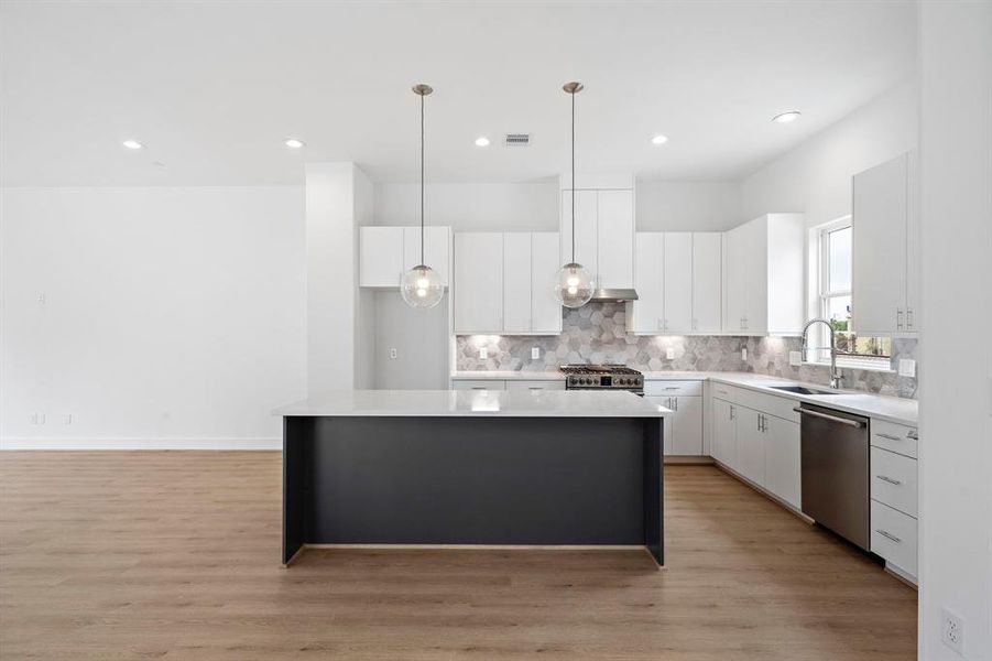 Spacious kitchen with gorgeous backsplash and quartz countertop