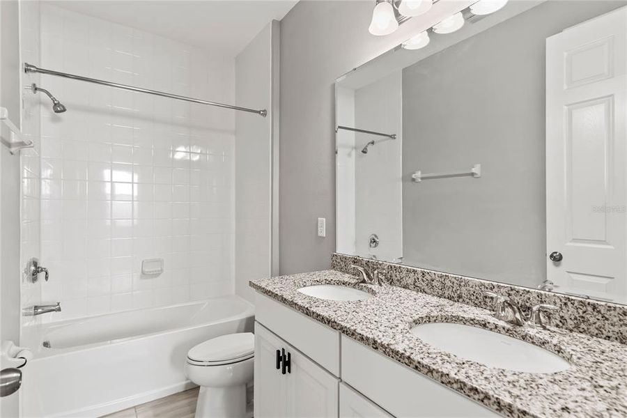 Hall Bath with Double Granite vanity and tiled shower/tub combo