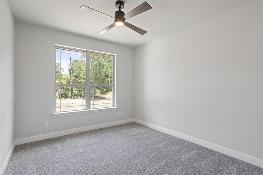 Unfurnished room with ceiling fan, carpet, and plenty of natural light