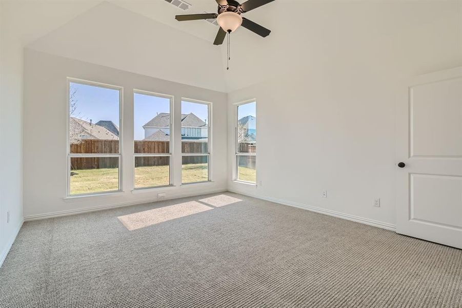 Unfurnished room with light carpet, a towering ceiling, and ceiling fan