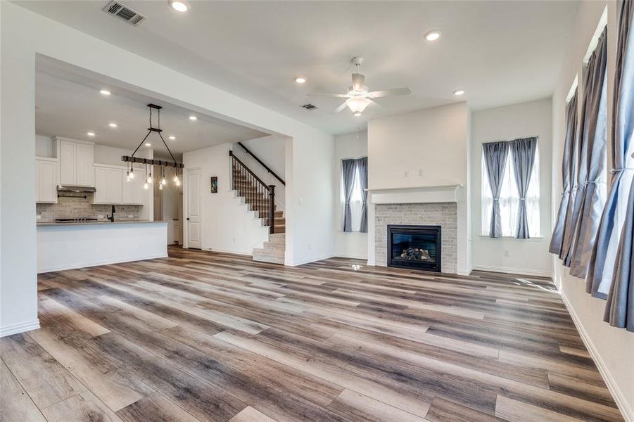 Unfurnished living room featuring ceiling fan and light hardwood / wood-style floors