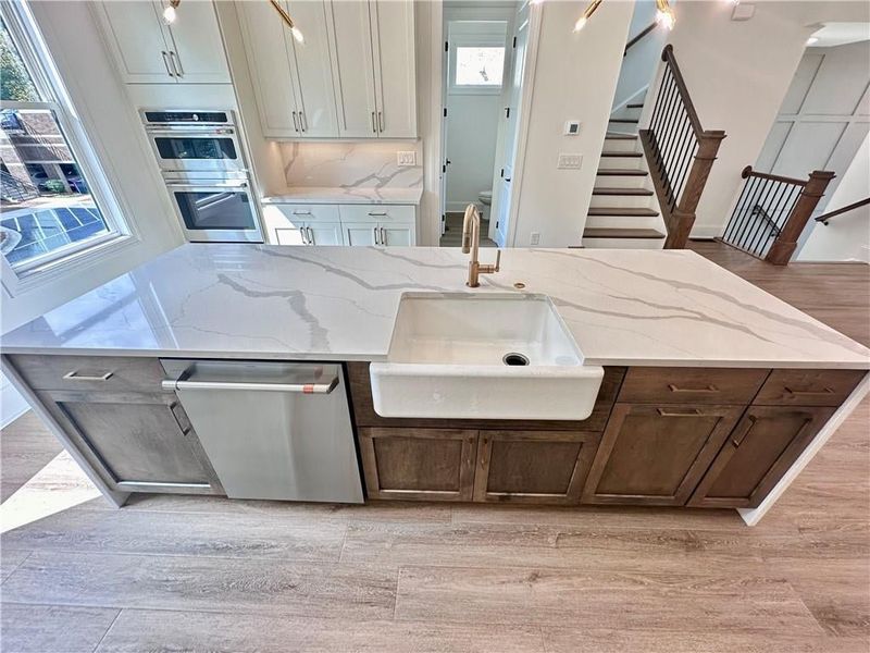 Beautiful farmhouse, porcelain sink, paired with champagne, bronze, plumbing fixtures