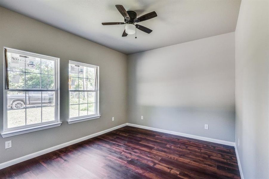 Unfurnished room featuring ceiling fan and dark hardwood / wood-style floors