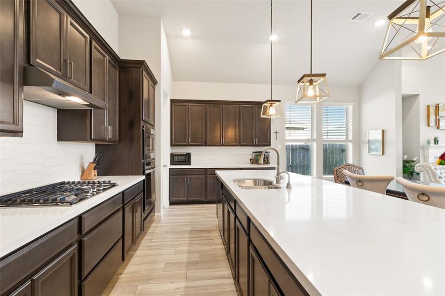 Sleek quartz countertops illuminated by stylish pendant lights.