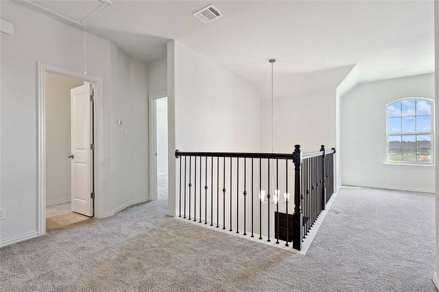 Hallway featuring light colored carpet