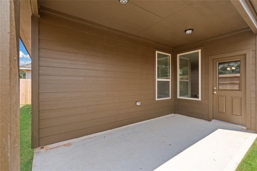 The covered patio is generously sized, providing ample space for various outdoor activities.